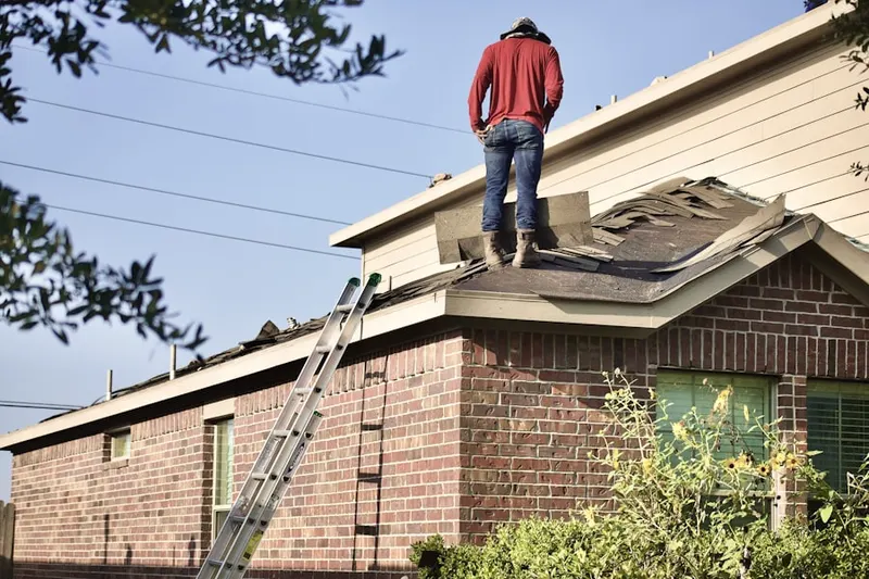 Professional roofer working on a residential roof in Mower